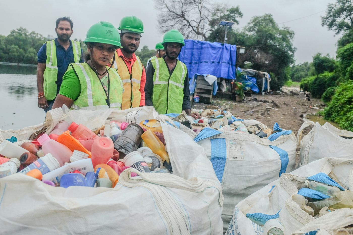 Team in safety vests with a bag of collected plastic in India
